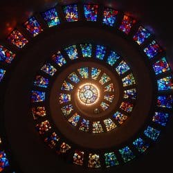 Vitrail coloré représentant des figures religieuses, illustrant la spiritualité et l’identité religieuse dans un contexte de protection des données.