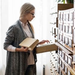 Femme consultant un fichier d’archives – symbolique de la gestion et de la classification manuelle des données