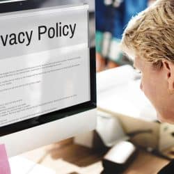 Bureau avec support “Privacy Policy” – illustration des règles de confidentialité intégrées dès la phase de conception