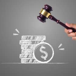 mains qui tiennent un marteau juridique pour évoquer les sanctions et la non-conformité